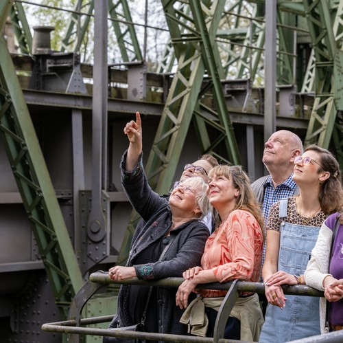 Eine Gruppe von Menschen schaut nach oben zum Schiffshebewerk